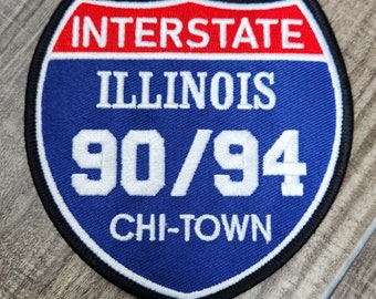 May include: A blue and red embroidered patch with the text "INTERSTATE ILLINOIS 90/94 CHI-TOWN"