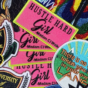 Może przedstawiać: Cztery różowe i żółte łatki z tkaniny z tekstem "Hustle Hard Girl - Madam CJ Walker" powtarzającym się na każdej łatce. Łatki są ułożone jedna na drugiej.