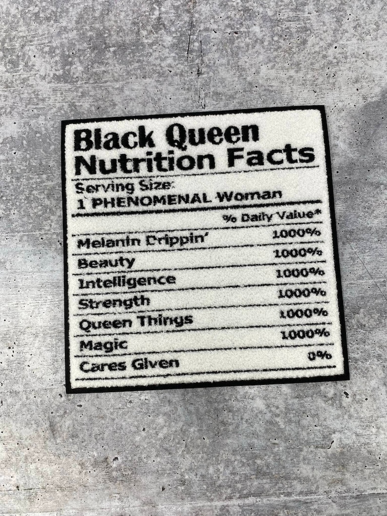 May include: A rectangular rug with a black border, featuring the text "Black Queen Nutrition Facts". The rug lists qualities like "Melanin Drippin'" and "Magic", each with a 1000% value, in black text.