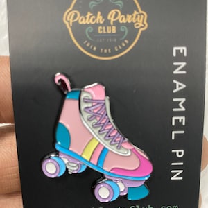 May include: Pink and blue roller skate enamel pin with white laces and yellow, pink, and blue stripes. The pin is on a black background with the text "Patch Party Club" and "ENAMEL PIN".