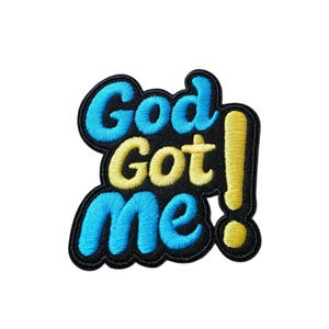May include: Embroidered patch with the phrase "God Got Me!" in blue and yellow lettering. The patch has a black border and a yellow exclamation point. The design is on a white background.