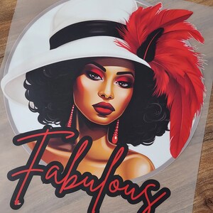 May include: A black and white illustration of a woman wearing a white hat with a red feather. The woman has red lipstick and earrings. The text "Fabulous" is written in red and black below the woman.