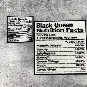 May include: Two white rectangular patches with black text that reads "Black Queen Nutrition Facts." The patches list "Melanin Drippin'," "Beauty," "Intelligence," "Strength," "Queen Things," and "Magic" with 1000% daily value.