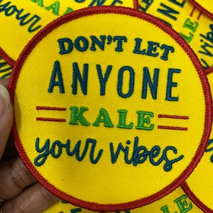 Könnte beinhalten: Gelber runder Patch mit roten Nähten. Der Patch hat den Text "Don't let anyone kale your vibes" in dunkelblauer und grüner Schrift.
