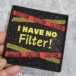 May include: Black iron-on patch with yellow and red caution tape and the text "I HAVE NO Filter!" in yellow thread.