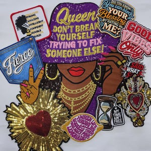 May include: A collection of embroidered and sequined patches featuring a large central figure wearing a purple hat with text, surrounded by smaller patches with phrases like Fierce, Good Vibes Only, and various heart and hourglass designs.