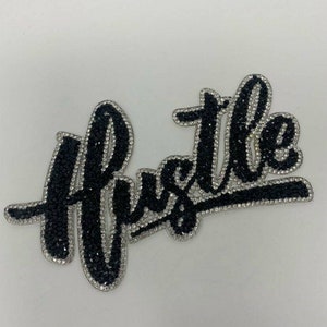 May include: Black and silver rhinestone iron-on patch with the word "Hustle" in a stylized font.