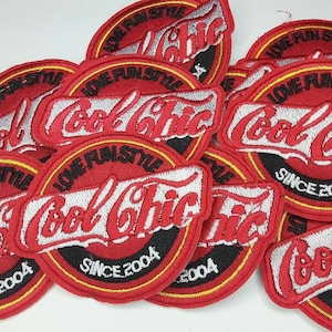 May include: A collection of red embroidered patches with the words "Cool Chic" and "Love Fun Style" in white and silver lettering. Each patch has a black and yellow border and the text "Since 2004".