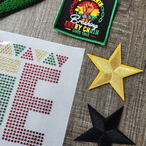 May include: A set of iron-on patches featuring a gold star, a black star, and a black patch with the text "JUNETEENTH Breaking Every Chain Since 1865".