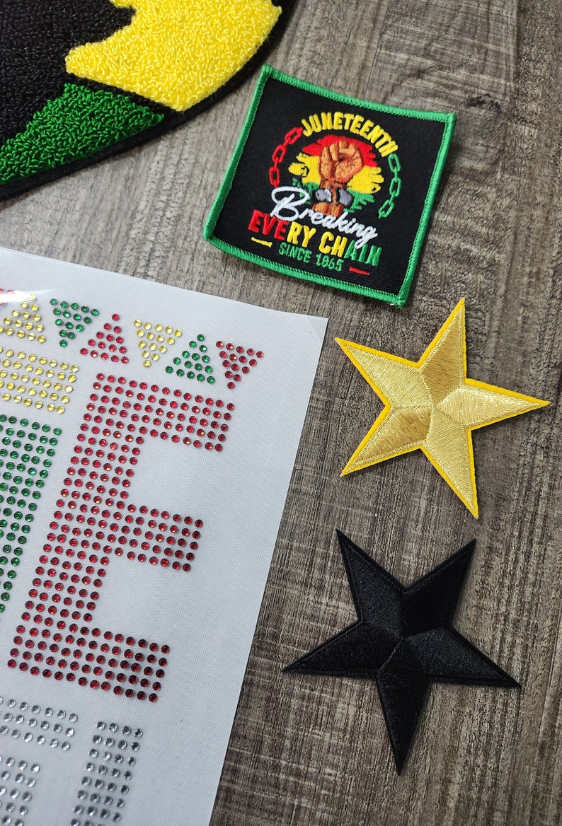 May include: A set of iron-on patches featuring a gold star, a black star, and a black patch with the text "JUNETEENTH Breaking Every Chain Since 1865".
