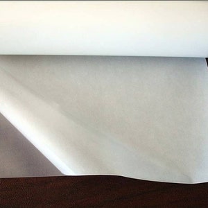 May include: A roll of white adhesive-backed fabric, with one end unrolled to show the adhesive side.