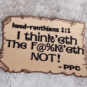 May include: A tan fabric patch with a distressed, parchment-like texture. The patch features black embroidered text that reads "hood-renthians 1:1 I think'eth The F@%&'eth NOT! -PPC".