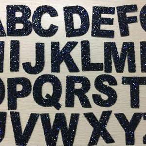 Peut inclure: Un ensemble de 26 lettres thermocollantes noires recouvertes de strass bleus, chaque lettre est d&eacute;coup&eacute;e individuellement et pr&ecirc;te &agrave; &ecirc;tre repass&eacute;e sur du tissu. Les lettres sont dispos&eacute;es en ordre alphab&eacute;tique de A &agrave; Z.