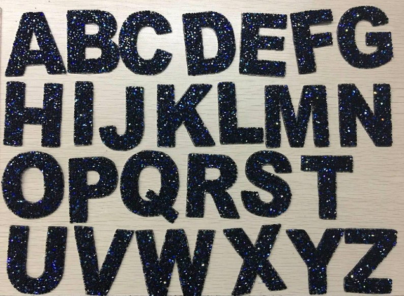 Peut inclure: Un ensemble de 26 lettres thermocollantes noires recouvertes de strass bleus, chaque lettre est d&eacute;coup&eacute;e individuellement et pr&ecirc;te &agrave; &ecirc;tre repass&eacute;e sur du tissu. Les lettres sont dispos&eacute;es en ordre alphab&eacute;tique de A &agrave; Z.