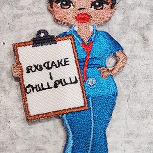 May include: Embroidered iron-on patch of a cartoon nurse holding a clipboard that says "RX Take Chill Pill". The nurse has brown skin, black curly hair, and is wearing a blue uniform with a red tie.