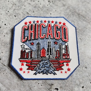 Può includere: Toppa ricamata bianca con una città in rosso, bianco e blu e la parola "CHICAGO" in lettere rosse e blu.