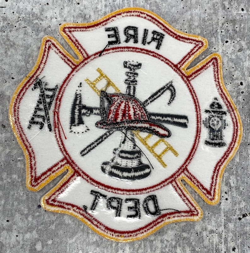 Op de afbeelding: Witte geborduurde patch met een rode rand en gouden afwerking. De patch heeft een brandkraan, een bijl, een ladder en een brandweerhelm. De tekst "FIRE DEPT" is geschreven in rood en goud.