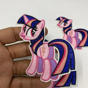 May include: Two pink and blue embroidered iron-on patches of Twilight Sparkle from My Little Pony. The patches are on a white background.