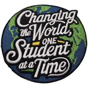 Puede incluir: Parche bordado con un diseño de globo terráqueo verde y azul. El texto dice "Changing the World One Student at a Time".