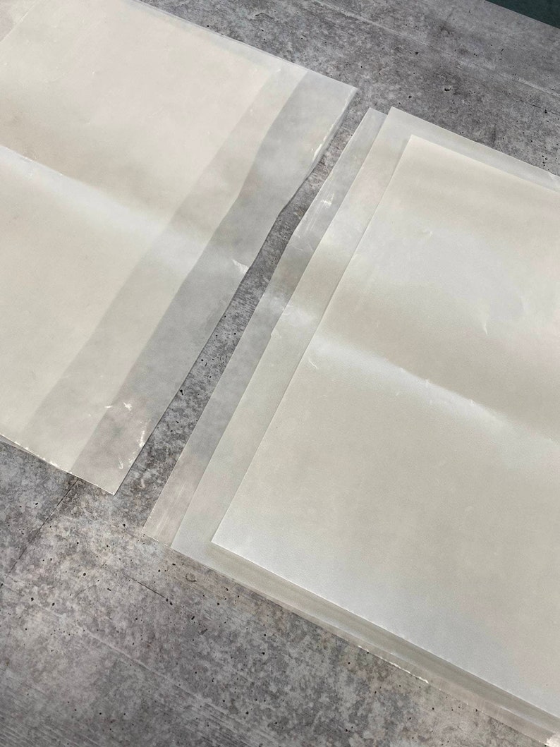 May include: A stack of clear plastic sheets, probably for protecting surfaces or crafts.