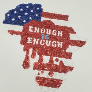Op de afbeelding: Een rood, wit en blauw paillettenpatch in de vorm van de Verenigde Staten met de woorden "Enough is Enough" in witte letters.