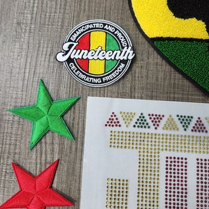 May include: A set of iron-on patches featuring a red, yellow, and green heart, a green five-pointed star, a red five-pointed star, and a round patch with the text "Emancipated and Proud Juneteenth Celebrating Freedom".