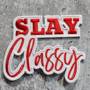Könnte beinhalten: Weißer gestickter Aufnäher mit roter Aufschrift "SLAY Classy".