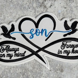 May include: Black and white embroidered patch with an infinity symbol and a heart. The infinity symbol has the words "Always on my mind" and "Forever in my heart". The heart has the word "son" inside. Two doves are flying above the heart.