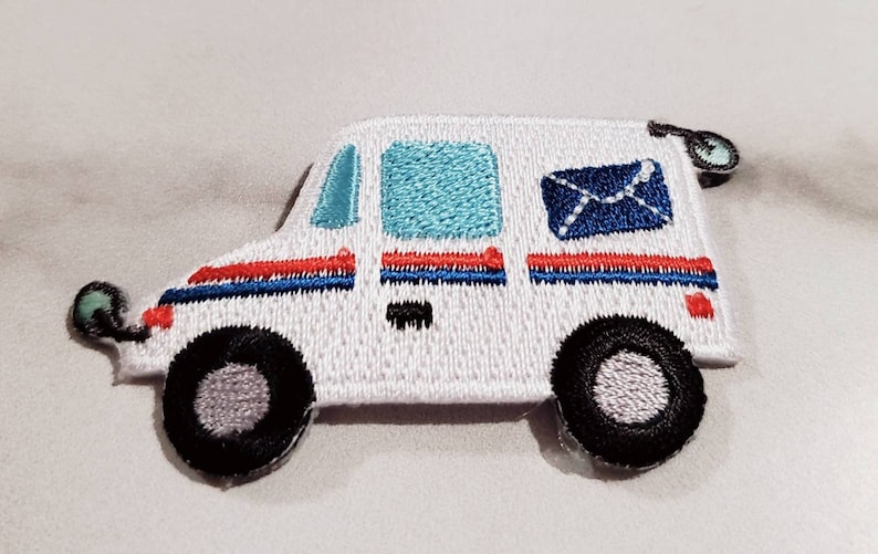 Pu&ograve; includere: Toppa ricamata a forma di camioncino postale bianco con dettagli rossi, blu e neri. Il camioncino ha una busta blu con una freccia bianca sul lato.