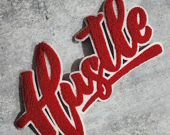 May include: Red felt patch with the word "Hustle" in white outlined letters.