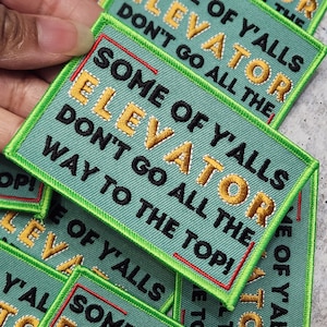 May include: Green and black embroidered iron-on patch with the text "Some of y'alls elevator don't go all the way to the top!"