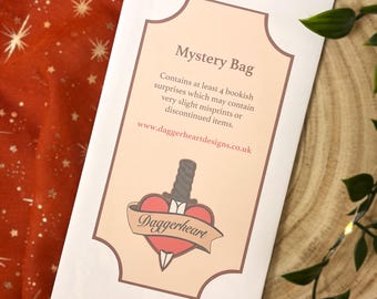 May include: A white paper bag with a scalloped top edge featuring the text Mystery Bag, Contains at least 4 bookish surprises which may contain very slight misprints or discontinued items, www.daggerheartdesigns.co.uk, and a Daggerheart logo.