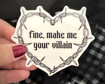 May include: A white heart-shaped sticker featuring a black barbed wire border and the text "fine, make me your villain" written in a gothic-style font. The sticker has a clean white background and sharp, detailed black line art.