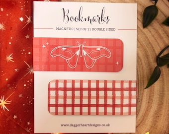 May include: A set of two rectangular magnetic bookmarks on a white display card. One bookmark features a red and white gingham pattern with a white moth illustration. The second bookmark has a red and white gingham pattern. Text reads Bookmarks.