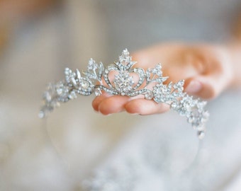 May include: A silver tiara with a heart-shaped center and crystal embellishments.