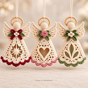May include: Three hanging crochet angel ornaments in cream yarn with gold halos. Each features a unique center cutout: a star, a heart, and a leaf motif. They are accented with red, pink, or green floral details and matching scalloped hems. Text reads: Design by Misbahkamal.