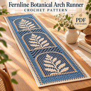 Puede incluir: Un camino de mesa rectangular de ganchillo con un esquema de color azul y crema con tres motivos de arco repetidos, cada uno con un diseño de hoja de helecho color crema. El texto "Fernline Botanical Arch Runner CROCHET PATTERN" es visible.
