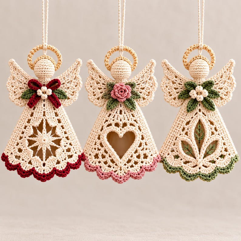 May include: Three hanging crochet angel ornaments in cream yarn, each featuring a halo, wings, and a unique central design. The first has a red bow, the second a pink rose, and the third green leaves. Each dress has a scalloped hem in red, pink, or green.