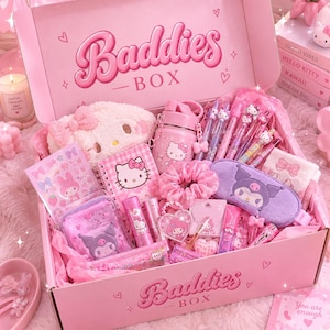 Peut inclure: Une boîte cadeau rose marquée Baddies BOX contenant divers articles de papeterie et accessoires à l'effigie de Hello Kitty et Kuromi. On y trouve une pochette en peluche, une gourde, des stylos, un carnet, un chouchou et un masque de nuit violet.