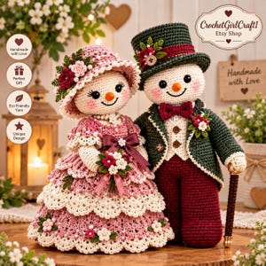 May include: Two crocheted snowman dolls dressed in formal attire. The female doll wears a pink ruffled dress with floral accents and a matching hat. The male doll wears a dark green top hat, a green jacket, and red trousers, holding a brown cane.
