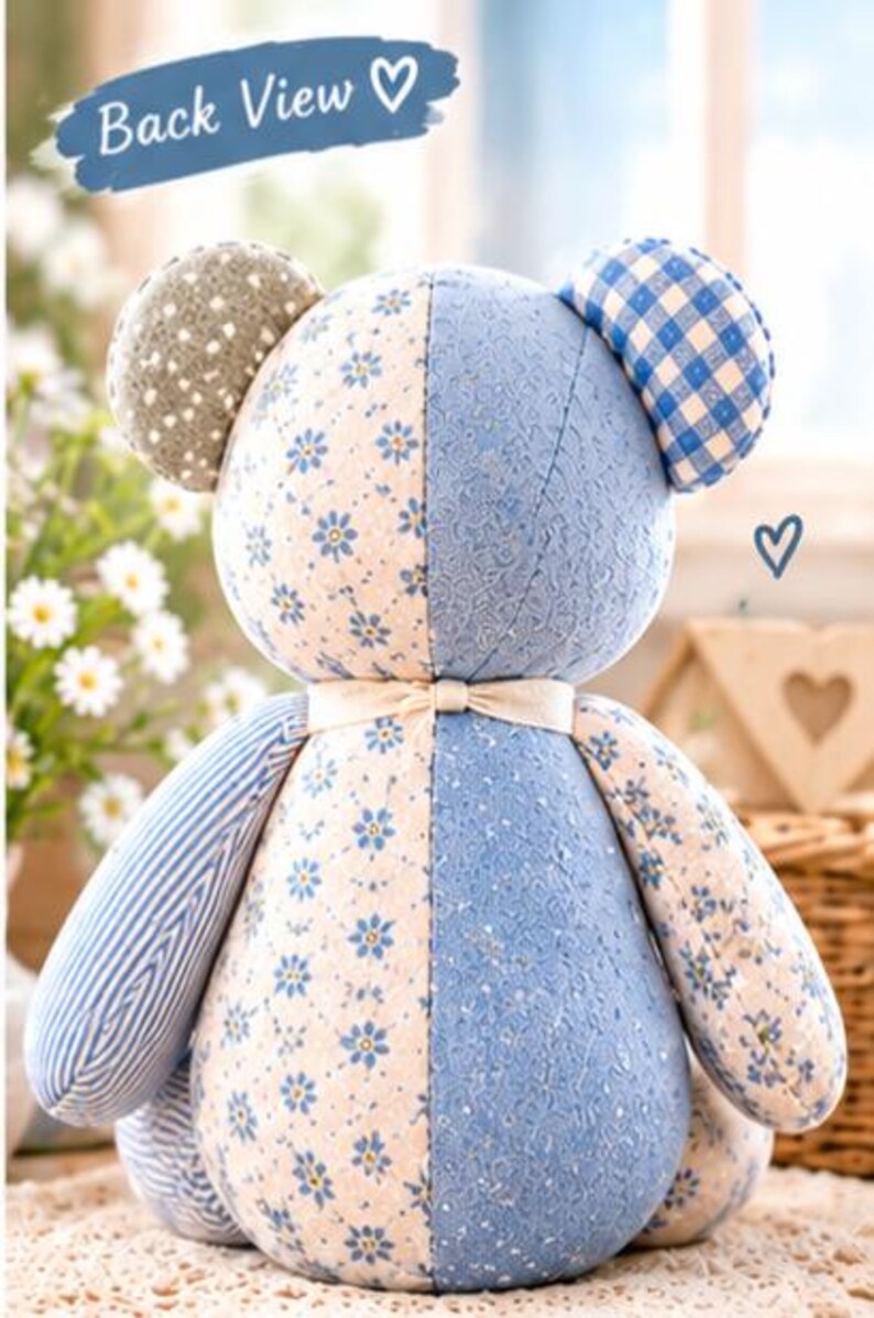 May include: A stuffed bear toy featuring a patchwork design with various blue and cream fabrics, including floral, striped, and gingham patterns. The bear has a cream-colored ribbon tied around its neck and text that reads Back View.