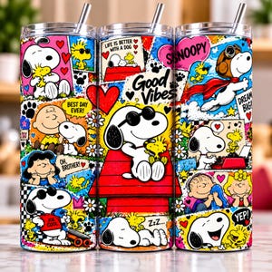 Könnte beinhalten: Ein zylindrischer Edelstahlbecher mit einer farbenfrohen Collage aus Snoopy- und Woodstock-Figuren. Das Design zeigt verschiedene Szenen, rote Herzen, Blumen und Texte wie Good Vibes, Life is Better with a Dog und Joe Cool.
