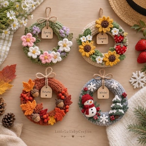 May include: Four circular crochet wreaths representing the seasons. The Spring wreath features pink and white flowers. The Summer wreath has sunflowers and strawberries. The Autumn wreath displays orange leaves and acorns. The Winter wreath shows a snowman and pine tree.