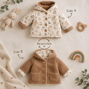 Könnte beinhalten: Eine wendbare Kapuzenjacke mit zwei Seiten: Seite A besteht aus cremefarbenem Stoff mit Blumen- und Waldtiermuster, während Seite B aus einfarbigem, braunem, strukturiertem Fleece besteht. Beide Seiten haben eine Knopfleiste und zwei Vordertaschen.