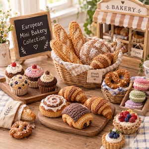 May include: A collection of crocheted bakery items including baguettes, a round loaf, croissants, pretzels, cupcakes, macarons, and fruit tarts. A chalkboard sign reads European Mini Bakery Collection, and a wooden bakery stand is visible.