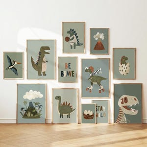 May include: A gallery wall set of twelve framed prints featuring illustrations of dinosaurs, a volcano, and eggs on a sage green background. The prints include text that reads BE BRAVE and STAY WILD, showcasing various prehistoric creatures.