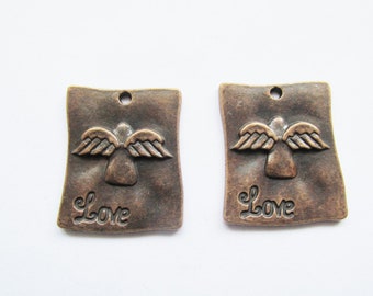 May include: Two antique bronze-colored metal charms with an angel design and the word "Love" inscribed on each.