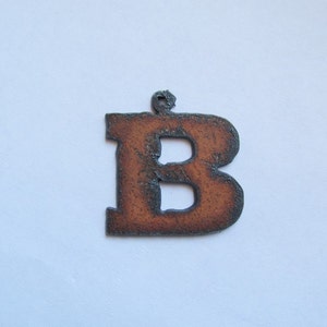 May include: A rusty brown metal letter B ornament. The letter is cut out of metal and has a rustic finish.