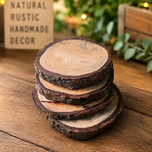 May include: A stack of four circular wooden coasters with visible tree ring patterns and rough, dark brown bark edges. Each coaster features a smooth, light brown top surface showing natural wood grain, stacked vertically on a flat surface.