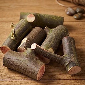 May include: A collection of small, cylindrical tree branch segments with rough, dark brown bark and exposed, light-coloured wood grain at the cut ends. Several pieces feature small, protruding branch stubs, creating a natural, raw appearance.